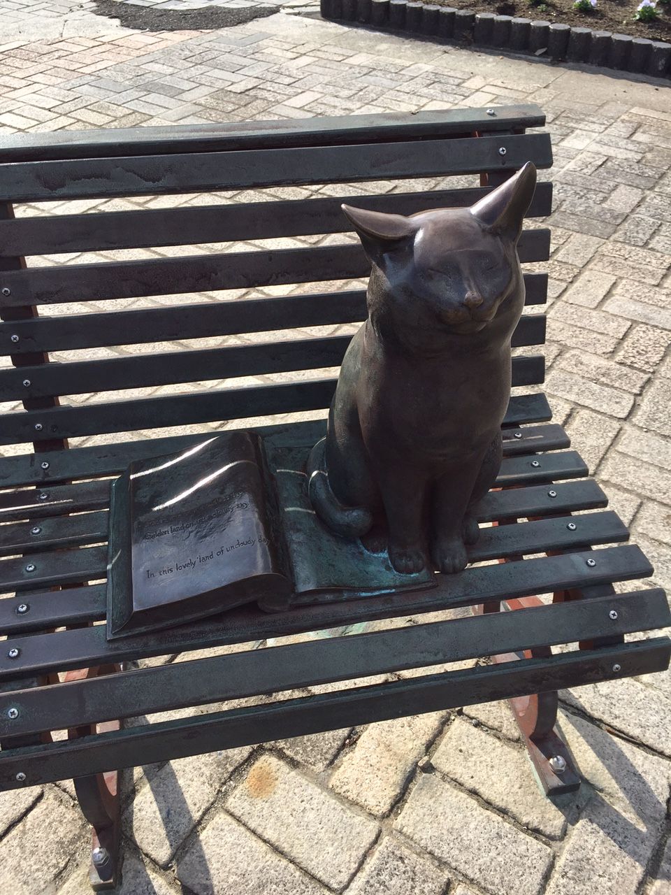 「晴朗な日」本の上に座るネコの像