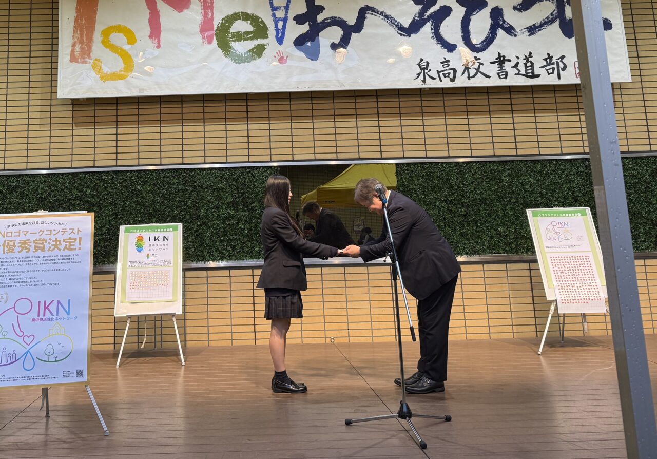 IKNロゴマークコンテストの最優秀賞を受け取る小川明日羽さん